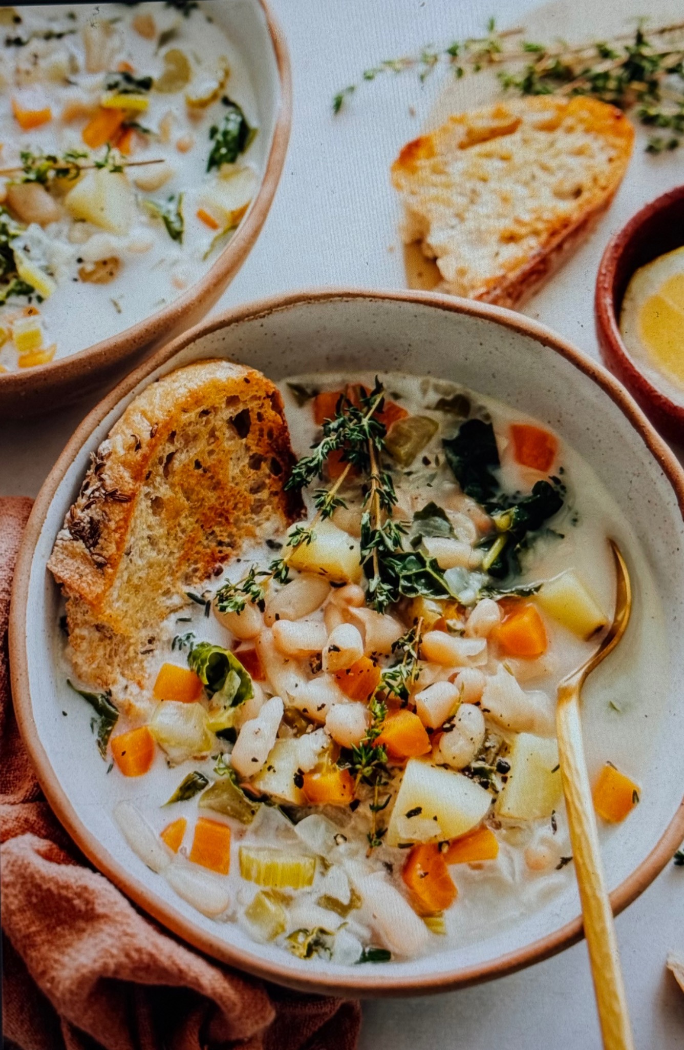 A nourishing bowl of white bean and vegetable soup with rustic toast