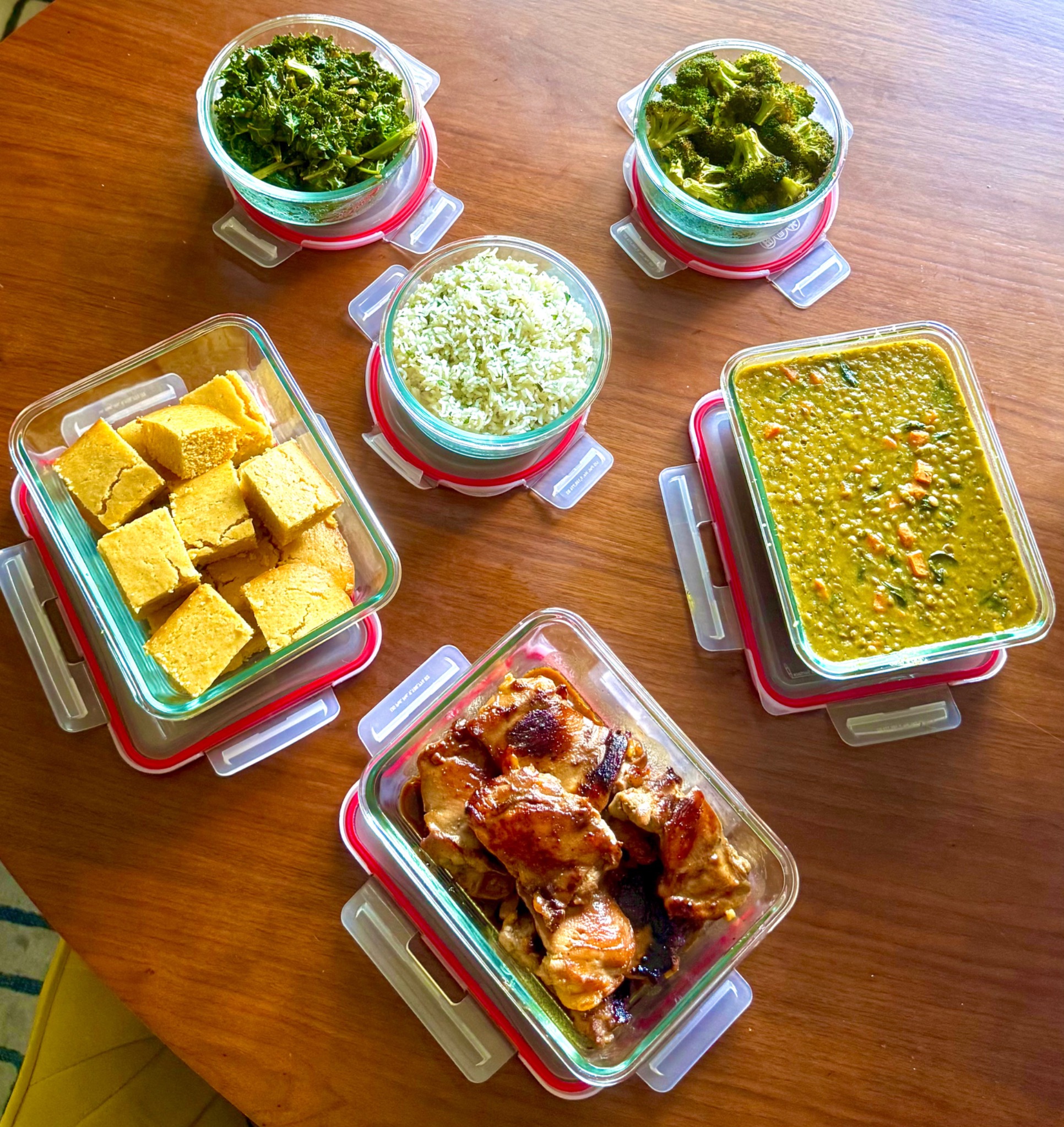 Real Mix And Match meal prep by Ebeth arranged in glass containers on a table
